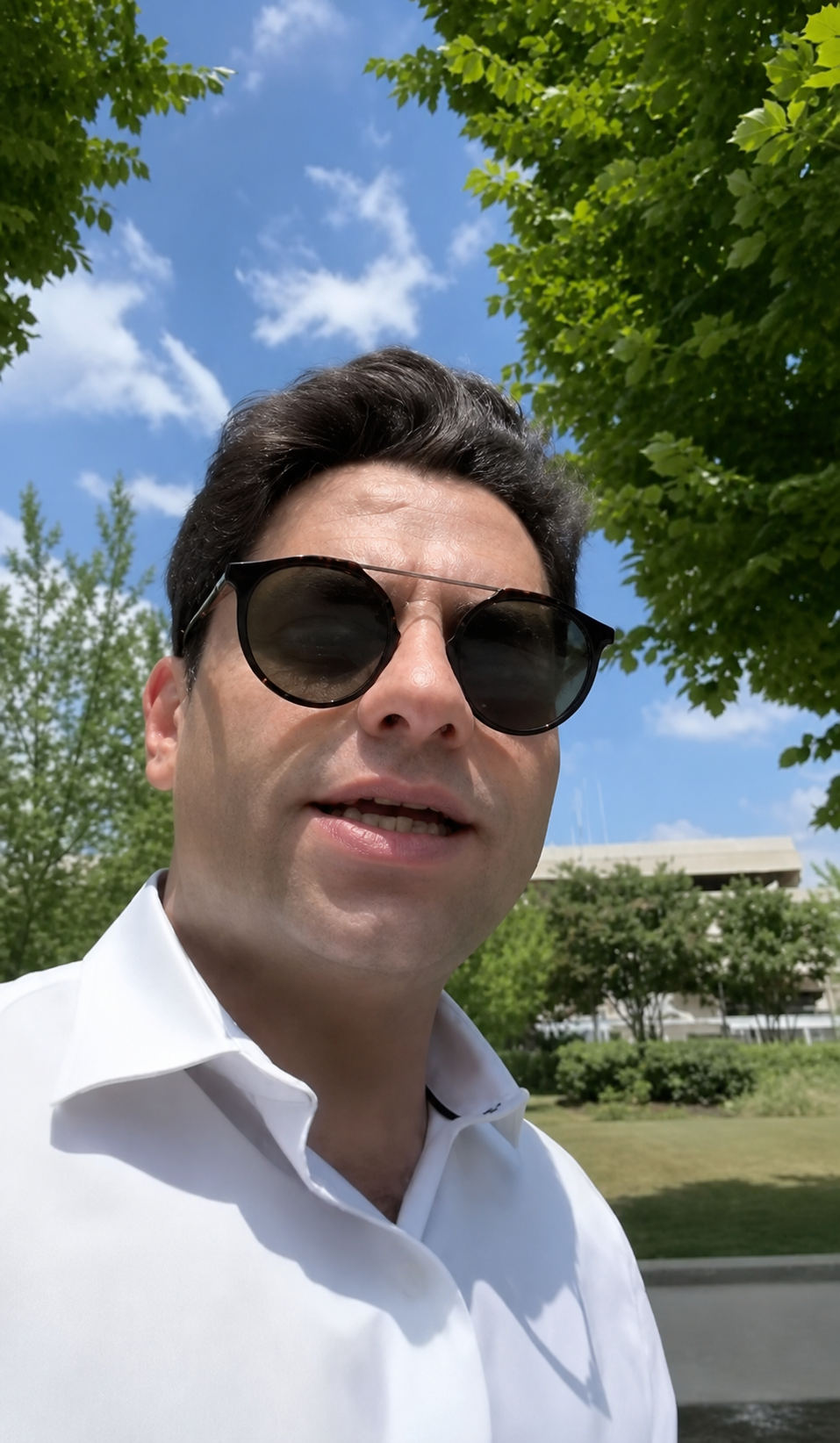Tarif Homsi walking outdoors while speaking to camera.